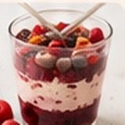 Parfait au yaourt, fruits rouges et granola servi dans un verre